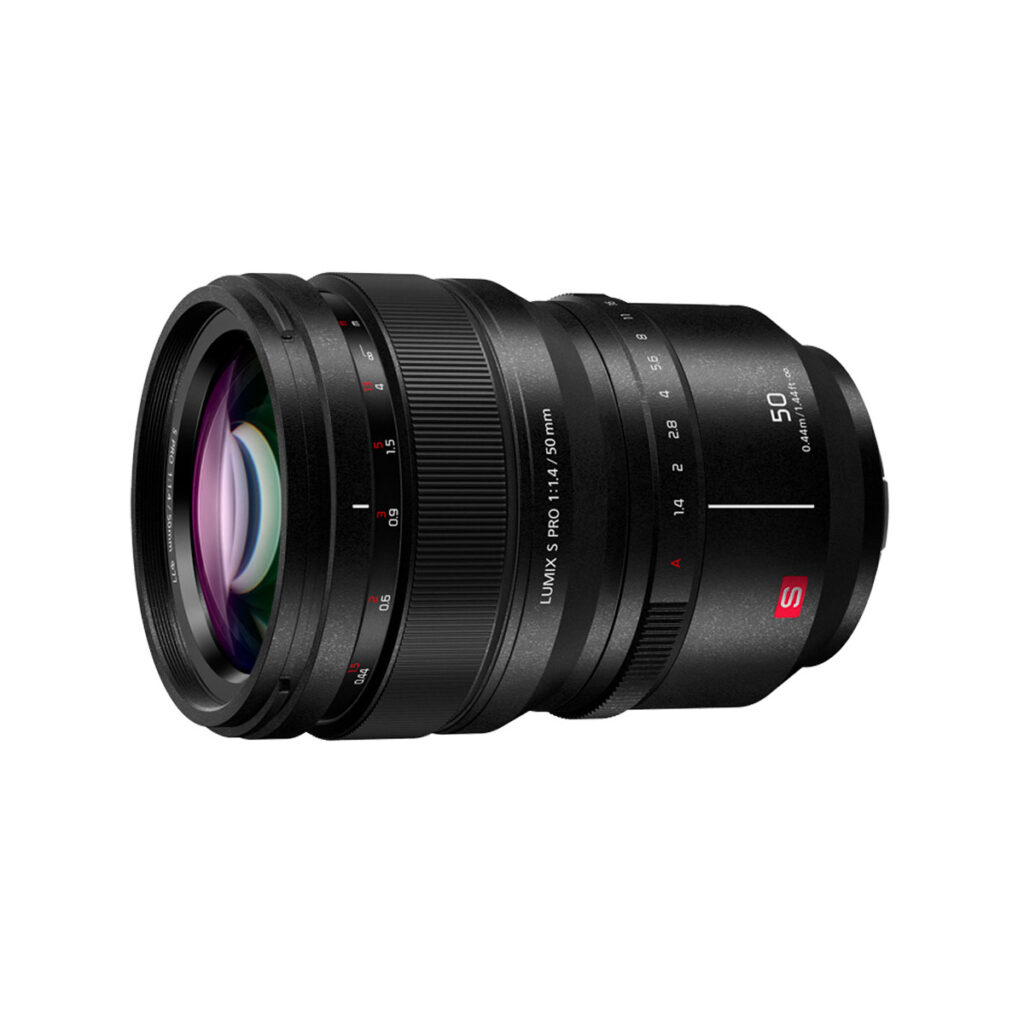 Lumix_S_Pro_50mm_003 Panasonic Lumix S Pro 50mm f/1.4 -objektiivi näkyy valkoisella taustalla, ja siinä on kuvioitu tarkennusrengas ja punainen S-logo objektiivin kiinnikkeen lähellä.