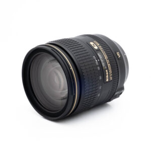 Nikon 24-120mm f4 G ED VR-2 Fujinon GF 50mm f/3.5 R LM WR (sis.ALV24%) - Käytetty -objektiivin etulasielementti ja aukon merkinnät näkyvät vinossa valkoisella taustalla.