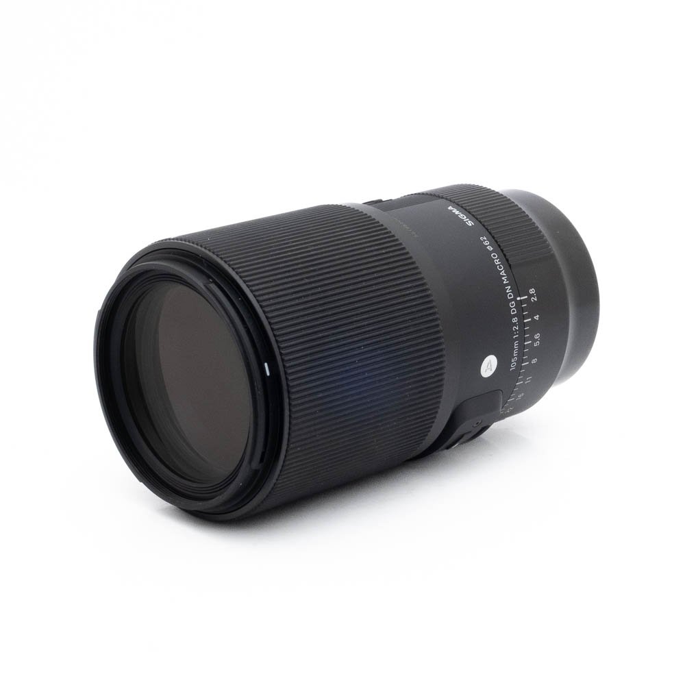 Sigma 105mm f28 DG DN Macro Sony-2 Fujinon GF 50mm f/3.5 R LM WR (sis.ALV24%) - Käytetty musta kameraobjektiivi, jossa on uurrettu kahva, valkoiset merkinnät ja kytkimet, näkyy valkoisella pohjalla pienessä kulmassa.