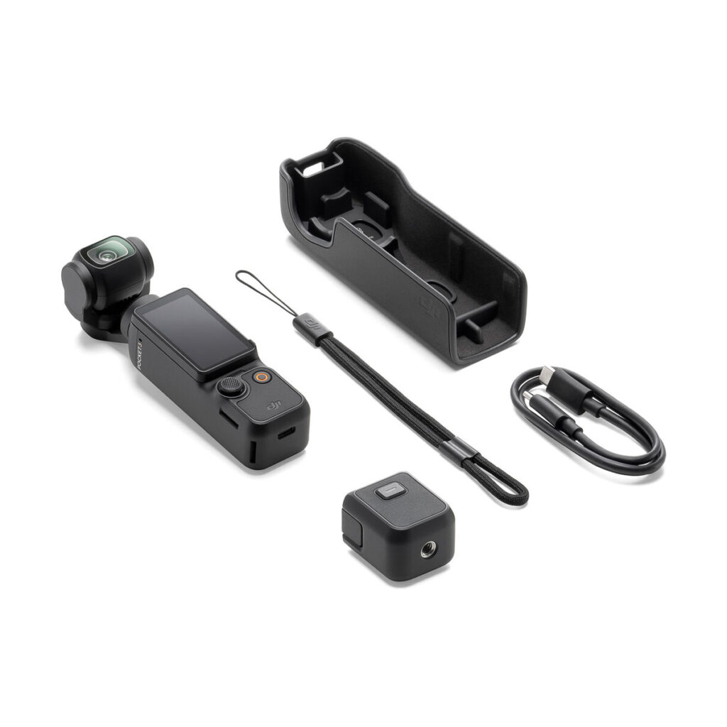 DJI Osmo Pocket 3 -videokamera, kompakti käsikamera, jossa on gimbaali, näkyy valkoisella taustalla yhdessä suojakotelon, rannehihnan, latauskaapelin ja pienen neliönmuotoisen lisävarusteen kanssa.