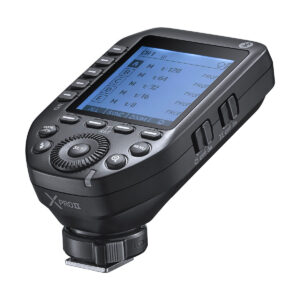Godox XPro II lähetin - Fujifilmin lähikuvassa näkyy sen suuri LCD-näyttö asetuksineen, useita painikkeita, säätöpyörä ja kuumakenkäkiinnitys alareunassa.