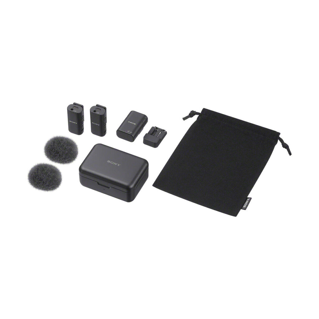 sony_ecm-w3_01 Sony ECM-W3 -langaton mikrofonijärjestelmä sisältää kaksi lähetintä, vastaanottimen, kaksi tuulilasia, latauskotelon kaapelilla ja mustan kiristysnauhapussin, kaikki kuvassa valkoisella pohjalla.