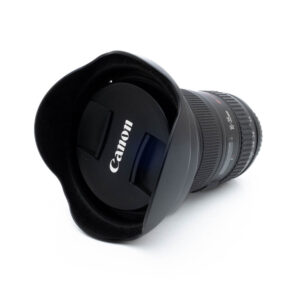 Canon 16-35mm f28 L II USM-3 Nikon Nikkor Z MC 105mm f/2.8 VR S (Kunto K5) -objektiivi, johon on kiinnitetty vastavalosuoja, kuvattuna kulmasta valkoisella taustalla. Nikonin logo näkyy selvästi objektiivin suojuksessa.