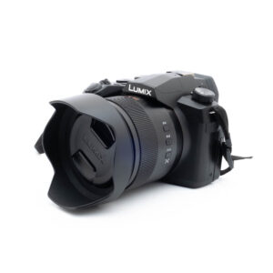 Lumix -5 Nikon Nikkor Z MC 105mm f/2.8 VR S (Kunto K5) - Käytetty objektiivi, johon on kiinnitetty suuri etuelementti ja vastavalosuoja, istuu valkoisella taustalla, ja siinä on yksityiskohtainen teksturointi ja selkeät säätörenkaat.