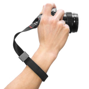 Peak-Design-Cuff-Black-2 Käsi pitää kameraa Peak Design Cuff Rannehihna - musta rannehihna, joka on kiinnitetty turvallisesti ranteen ympärille valkoisella pohjalla.