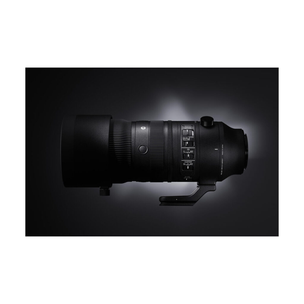 sigma_70-200_sport_dn_01 Sigma 70-200mm f/2.8 DG DN OS Sport -objektiivi Sony E:lle on esillä tummalla kaltevuusasteikollisella taustalla, ja sen tyylikäs musta runko ja sisäänrakennettu jalustakiinnitys korostuvat taustavalossa.