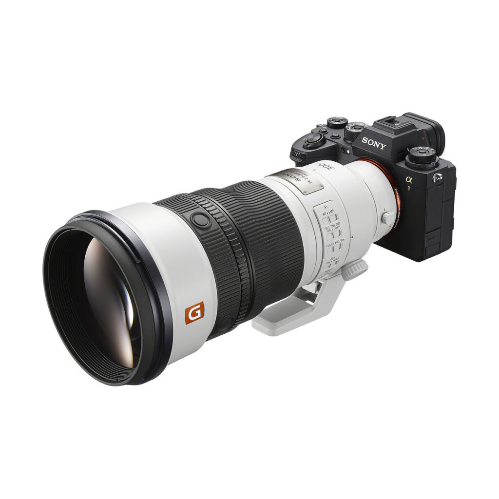 sony_fe_300mm_f28_gm_02 Sony Alpha -kamera, johon on kiinnitetty Sony FE 300mm f/2.8 GM OSS -objektiivi ja jossa on useita säätörenkaita ja kytkimiä valkoisella taustalla.
