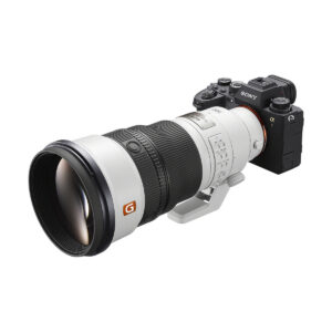 sony_fe_300mm_f28_gm_02 Sony Alpha -kamera, johon on kiinnitetty Sony FE 300mm f/2.8 GM OSS -objektiivi ja jossa on useita säätörenkaita ja kytkimiä valkoisella taustalla.