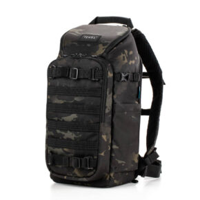 Tenba Axis V2 16L Reppu MultiCammusta -kamerareppu sisältää mustan ja harmaan maastokuvioinnin, useita vetoketjullisia lokeroita, säädettävät hihnat, sivutaskut ja yläkahvan. Reppu on kuvattu pystyasennossa valkoisella pohjalla.