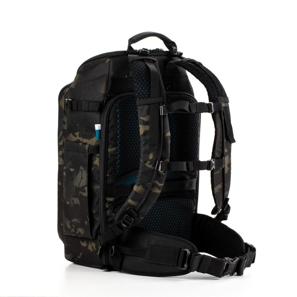 tenba_axis_24l_camo_01 Tenba Axis v2 24L reppu MultiCammusta -kamerareppu mustassa ja tummassa camossa näkyy sivulta ja takaa, pehmustetut olkahihnat, rintahihna, vyötäröhihna ja ulkopuolinen sivutasku, jossa on kynä.