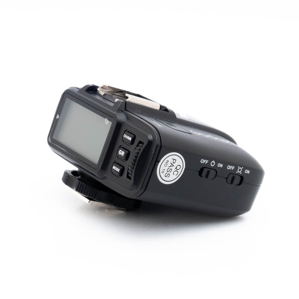 Godox X1TN-1-2 Käytetty Godox X1T-N radiolähetin (sis.ALV24%), musta, jossa on LCD-näyttö, ohjauspainikkeet ja on/off-kytkin valkoisella pohjalla.