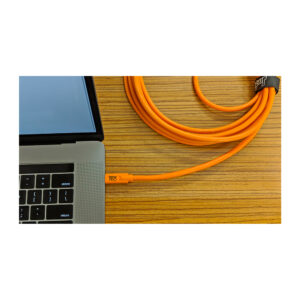 Tether-Tools-TetherPro-USB-C-to-20-Micro-B-5-pin The Tether Tools TetherPro USB-C-2.0 Micro-B 5-pin cable, twisted and secured with Velcro, is partially visible next to the laptop on the wooden surface.