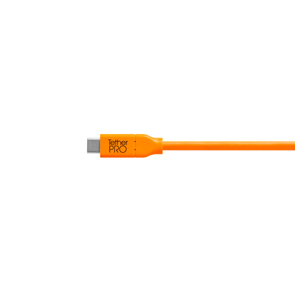 TetherPro-USB-C-to-USB-A-Female-Adapter-02 Oranssinvärinen Tether Tools TetherPro USB-C- ja USB-A-liitäntäsovitin näkyy valkoista taustaa vasten, ja siinä on näkyvissä liitin ja kaapeli, jonka liittimen koteloon on painettu "Tether PRO".