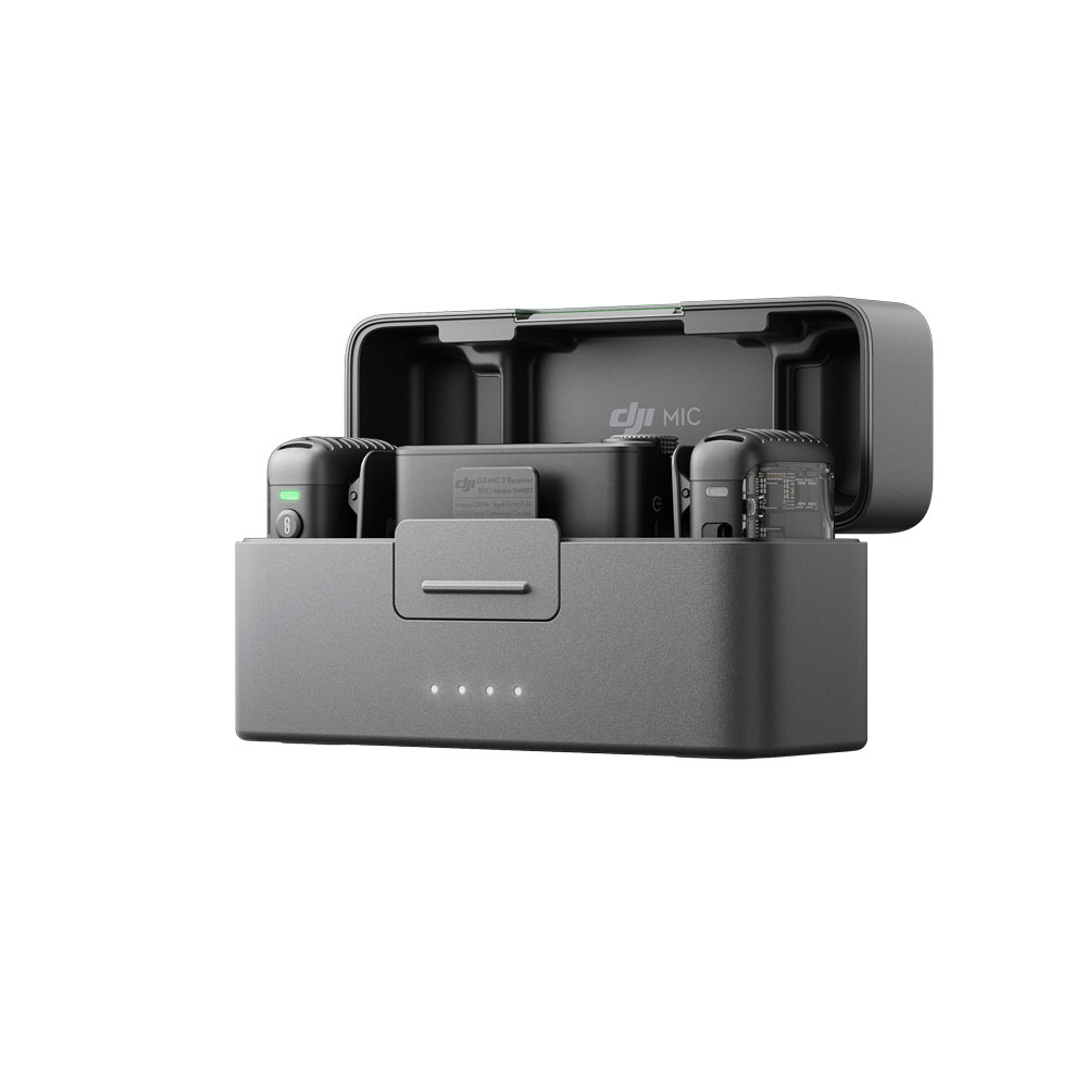DJI_Mic2_1+2_002 DJI Mic 2 Dual Kit -langaton mikrofonijärjestelmän latauskotelo on avattu, ja sen sisällä on kaksi mikrofonia ja vastaanotin, ja sen kompaktin harmaan muotoilun etupuolella on neljä valaistua merkkivaloa.