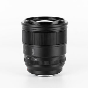 Viltrox AF PRO 27mm f/1.2 -objektiivi, Fuji X -objektiivi seisoo pystyasennossa valkoisella taustalla, ja siinä on kaiverretut tarkennus- ja aukkorenkaat sekä tyylikäs, sylinterimäinen musta muotoilu.
