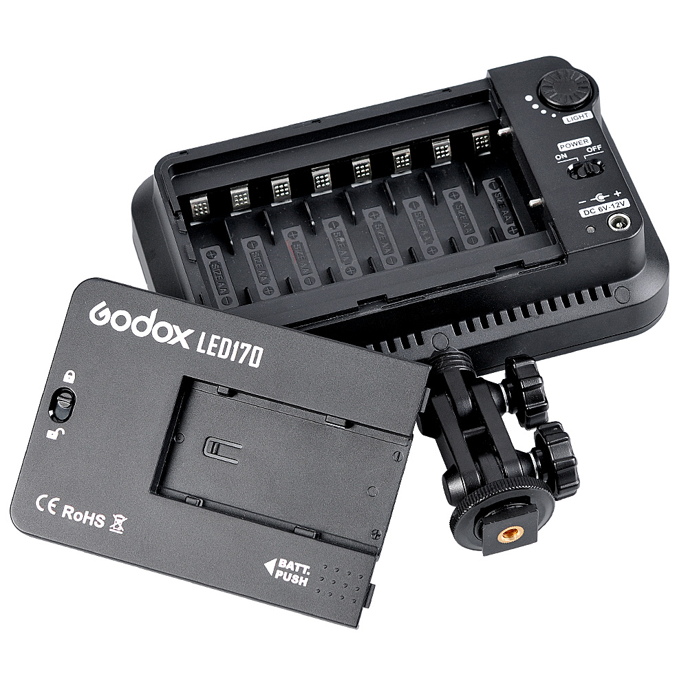 1373351225_850 Godox Led 170 -videovalaisin, jossa on akkulaturi ja säädettävä kiinnitysteline, näkyy ylhäältäpäin valkoisella pohjalla, jossa näkyvät akkupaikat ja säätöpyörät.