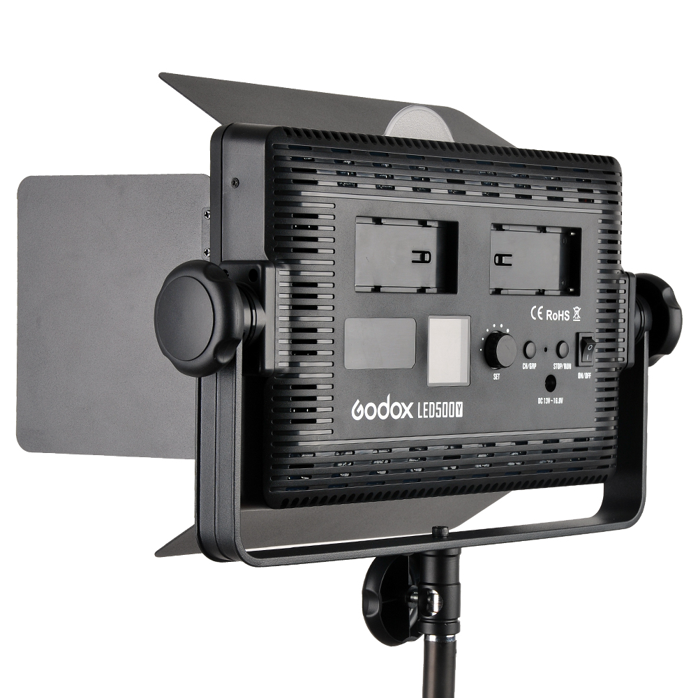 1448269121_407 Godox LED 500Y Tungsten -videovalaisinpaneeli, jossa on säädettävät lato-ovet, ohjauspainikkeet ja kaksi paristopaikkaa, on asennettu valotelineeseen ja katsottu takaa.