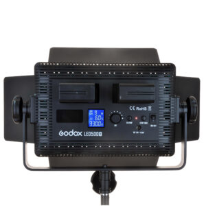 Godox LED 500C Bi-Color -valaisimen takanäkymä, jossa näkyy kaksi akkupaikkaa, säädettävät lato-ovet, ohjauspaneeli ja LCD-näyttö, joka näyttää asetukset, asennettuna valaisinjalustaan.
