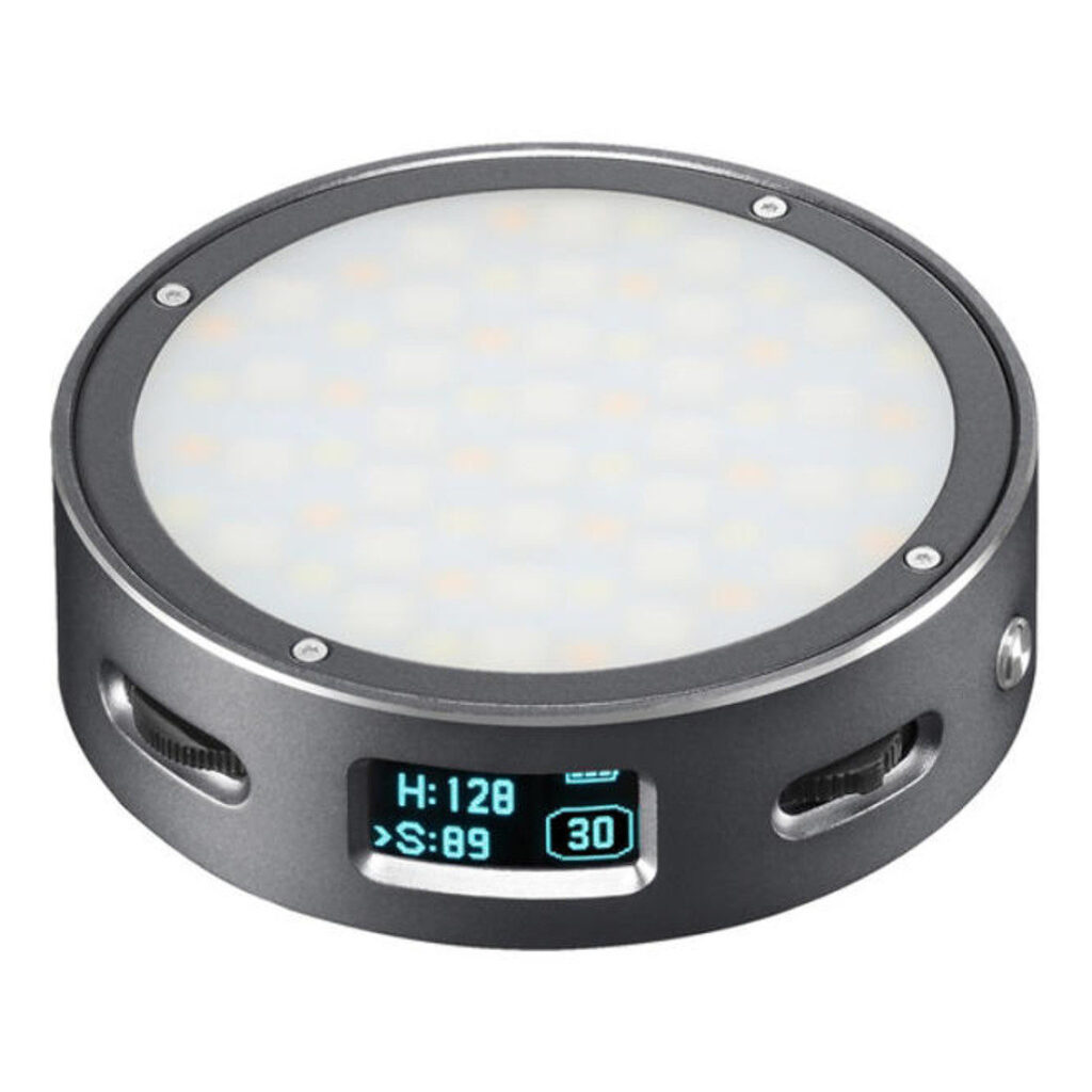 1600865320_684 Godox R1 Mobile RGB LED-valaisin - Harmaa on pyöreä, kannettava LED-valaisin, jossa on digitaalinen näyttö ja asetukset ja joka on sijoitettu metalliseen koteloon, jossa on venttiilimäiset sivuurat.
