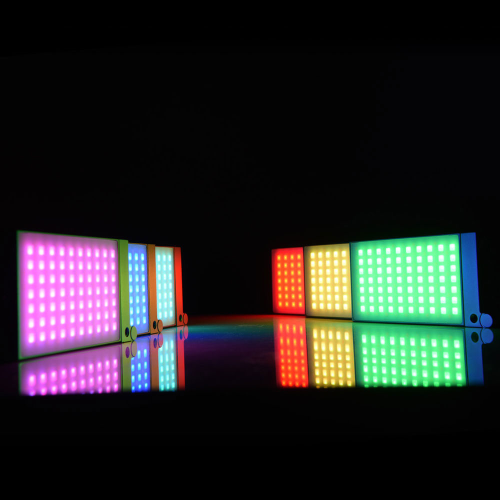 Godox M1 Mobile RGB LED -valaisin - Harmaa heijastaa eloisat vaaleanpunaiset, violetit, siniset, keltaiset, punaiset ja vihreät valot mustalle taustalle luoden värikkäitä heijastuksia alla olevalle kiiltävälle pinnalle.