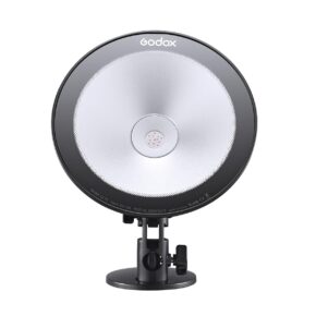 1609842606_292 Godox CL10 Ambient LED -valaisimessa on pyöreä muotoilu, jossa on hopeinen heijastin ja musta reunus, ja se on asennettu säädettävään jalustaan, edestäpäin valkoista taustaa vasten.