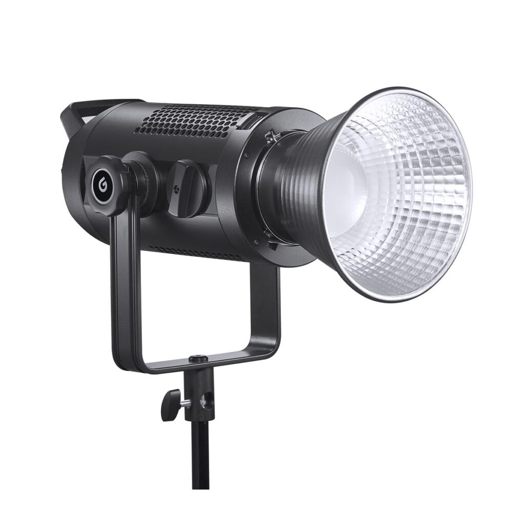 1611305676_220 Godox SZ200Bi zoomattava kaksivärinen LED-videovalaisin, jossa on suuri hopeinen heijastin, asennettu jalustalle ja hieman vasemmalle kallistettu, valkoista taustaa vasten.
