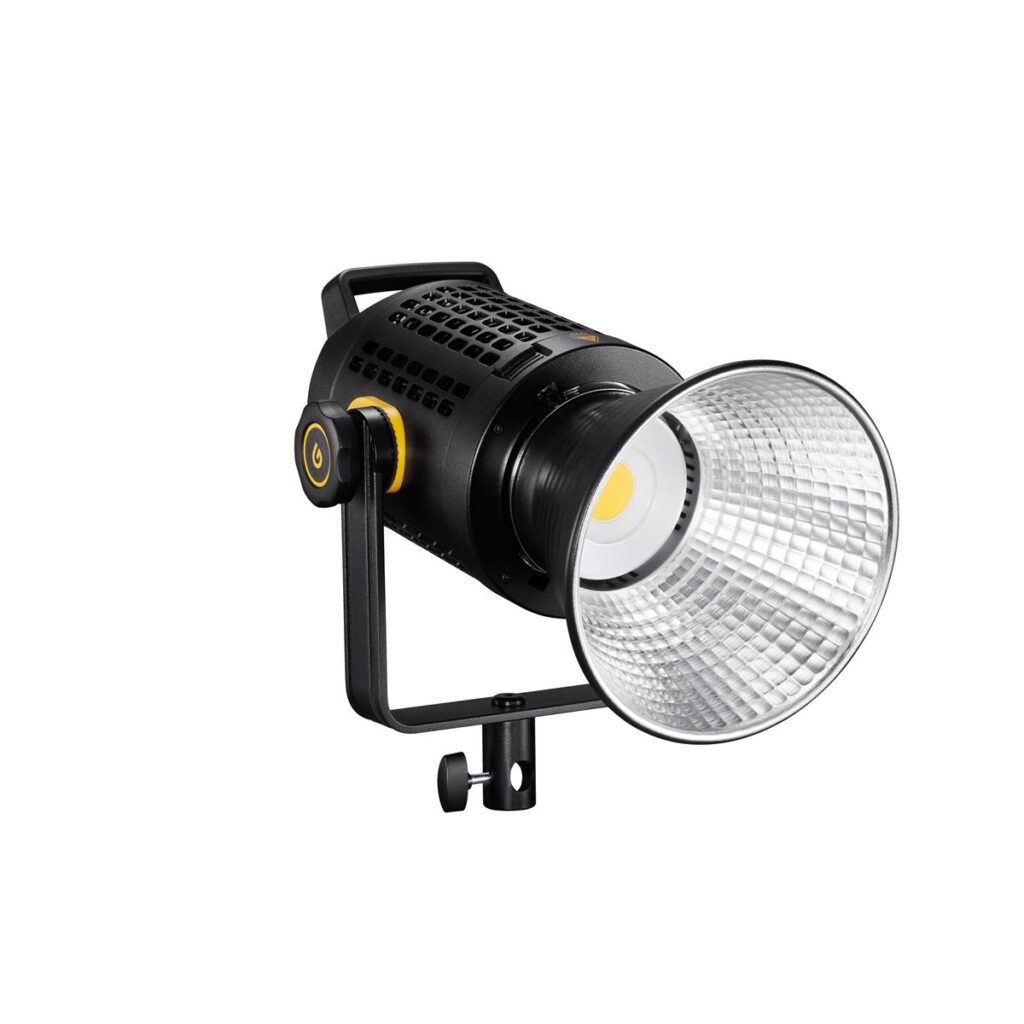 1612169486_337 Godox UL60 Silent -videovalaisin on musta studio-LED, jossa on kahva, säädettävä jalusta ja suuri heijastava hopeinen kartio, jossa on keltainen LED. Virtapainike sijaitsee laitteen sivulla.