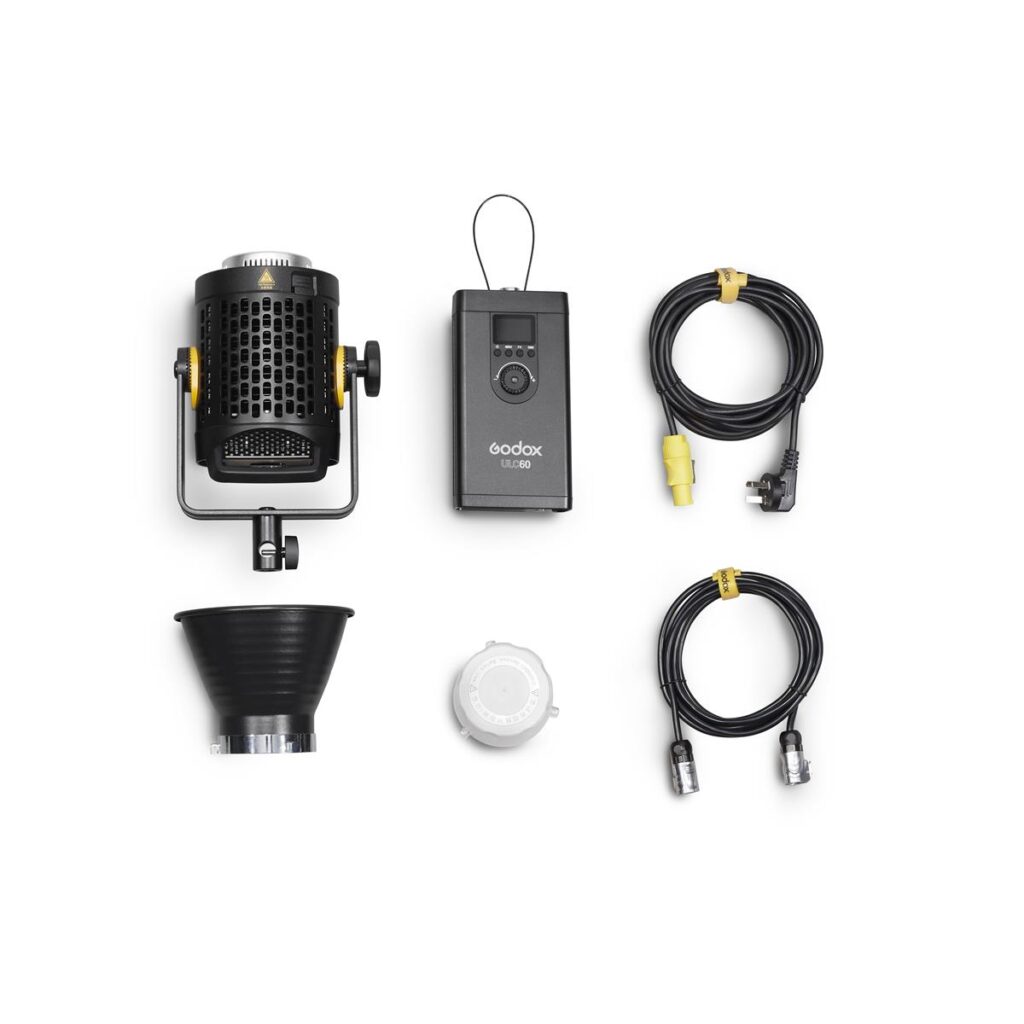 1612169487_454 Godox UL60 Hiljainen videovalo -LED-valo kitin komponentit valkoisella pohjalla: LED-valo, kaukosäädin, heijastin, valkoinen diffuusori ja kaksi mustaa kaapelia liittimillä.