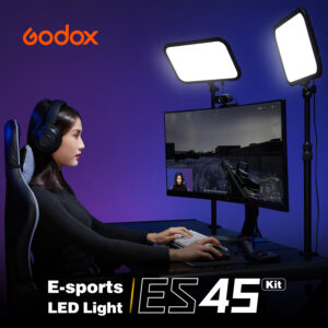 1612784952_784 A woman wearing a headset plays a first-person shooter game on her computer desk, illuminated by two Godox E-sports LED Light ES45 Kit panels on a stand.