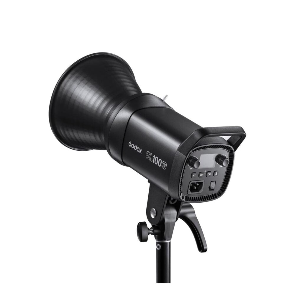 1621594083_366 Musta Godox LED SL100Bi Bi-Color LED-valaisin on asennettu jalustalle, kuvassa takaa, jossa ohjauspainikkeet ja kahva näkyvät. Siinä on suuri heijastin ja vankka rakenne, ihanteellinen valokuvaukseen tai videokuvaukseen.