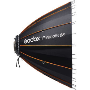 1637062208_004 Godox Parabolic Reflector Zoom Box P88Kit, musta parabolinen softbox, jossa on oranssit korostukset, näkyy sivulta, ja sen kankaassa on metalliset tuet ja valkoinen Godox-logo.