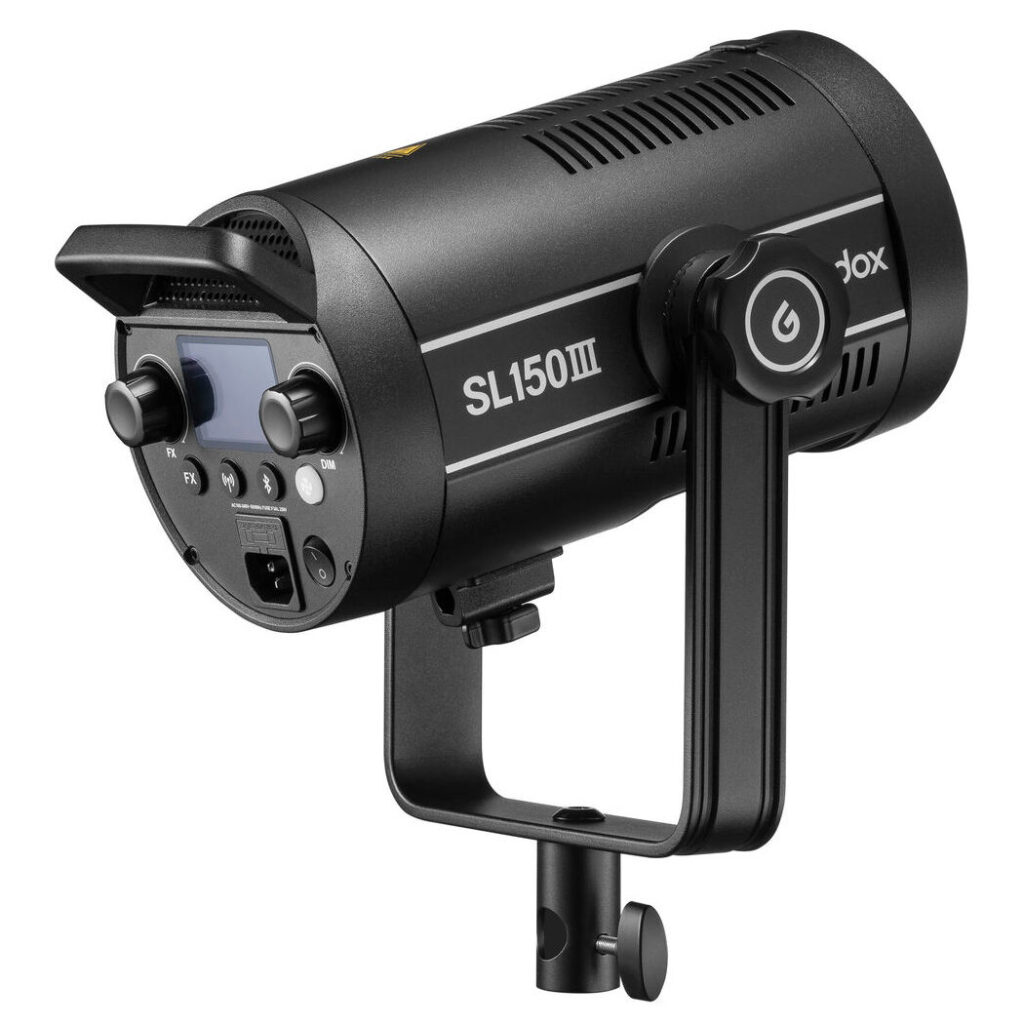 1675173999_040 Godox SL150III LED-videovalaisin -LED-valo mustana, jossa on säätönupit, LCD-näyttö ja kiinnityskannatin, näytetään kulmikkaasta sivu- ja takanäkymästä.