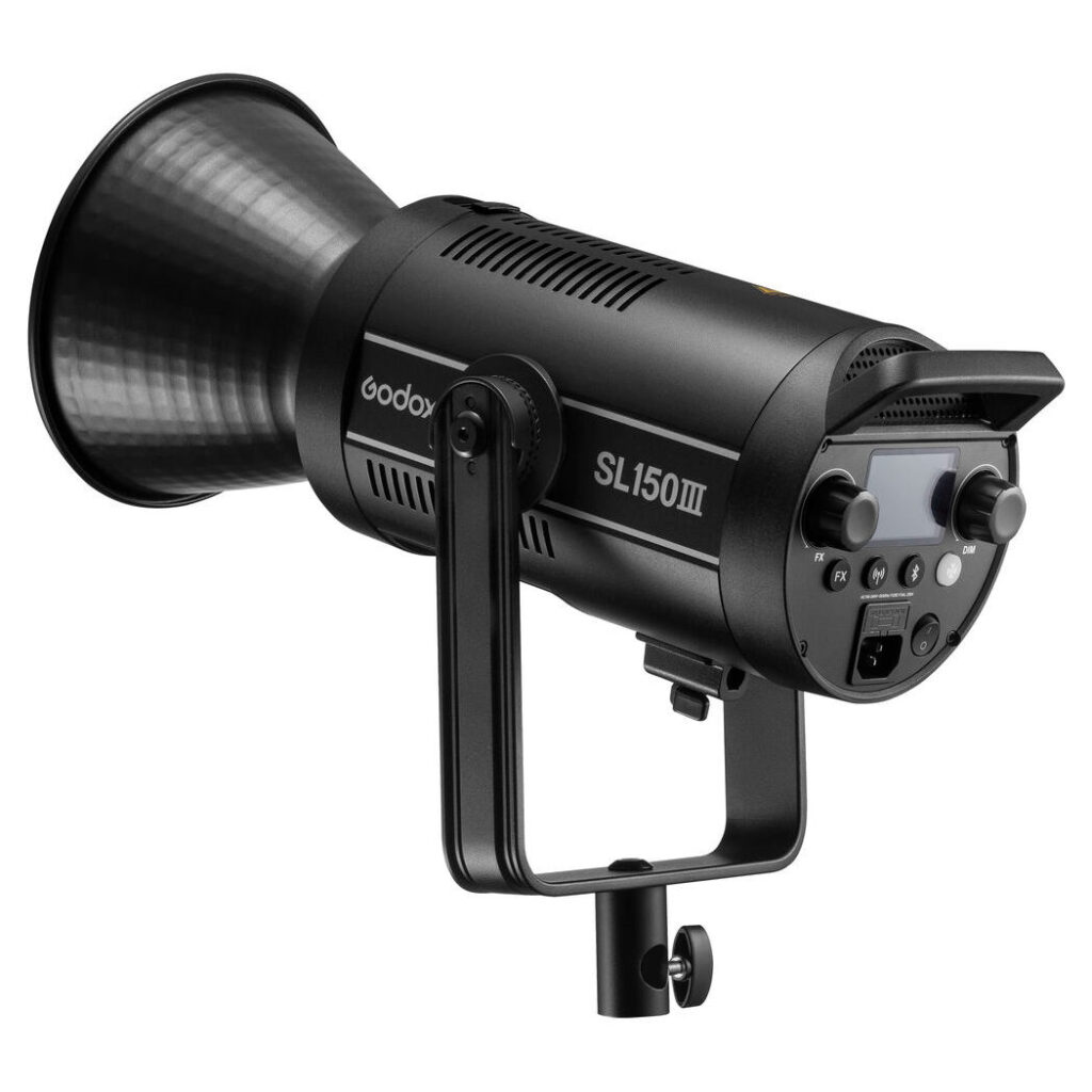 1675174005_569 Godox SL150III LED-videovalaisin -LED-valo näkyy mustana, jossa on suuri heijastin, ohjauspaneeli ja kiinnitysteline valkoista taustaa vasten.