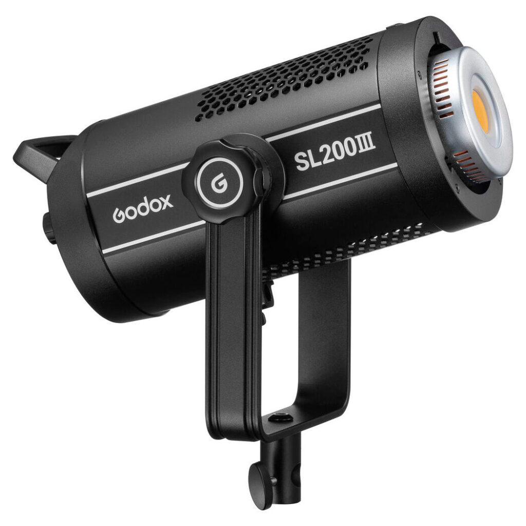 1675234816_711 The Godox SL200III LED video light in black, with a cylindrical body, cooling vents and mounting bracket, is presented at a three-quarter angle to the right.