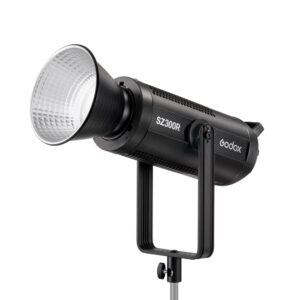 1683018529_007 Mustan värinen Godox SZ300R Zoom RGB LED Video Light -LED-valo, jossa on suuri heijastin, on asennettu metallijalustalle ja näytetään etupuolelta valkoista taustaa vasten.