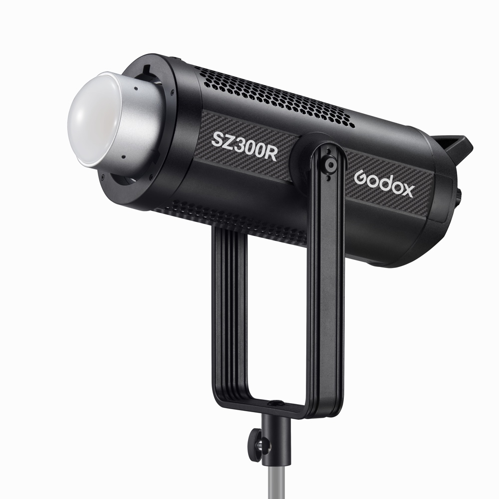 1683018530_262 Godox SZ300R Zoom RGB LED RGB Video Light -LED-valo, musta, hopeisella heijastimella, jalustalle asennettuna valkoista taustaa vasten.