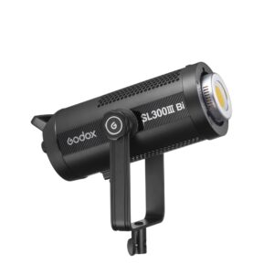 1692103363_390 Godox SL300IIIBi Bi Color LED-valo-LED-valo on musta, lieriömäinen studiovalo, jossa on tuuletetut sivut ja tukeva kiinnitysrunko, kuvassa hieman vinossa valkoista taustaa vasten.