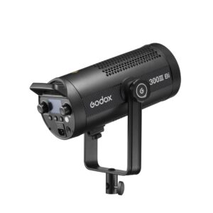 1692103364_167 Musta Godox SL300IIIBi Bi Color LED Light -LED-valo (300W), jossa on ohjauspainikkeet, näyttö ja tuuletettu runko, on asennettu joke-kannattimeen ja näytetään valkoista taustaa vasten.