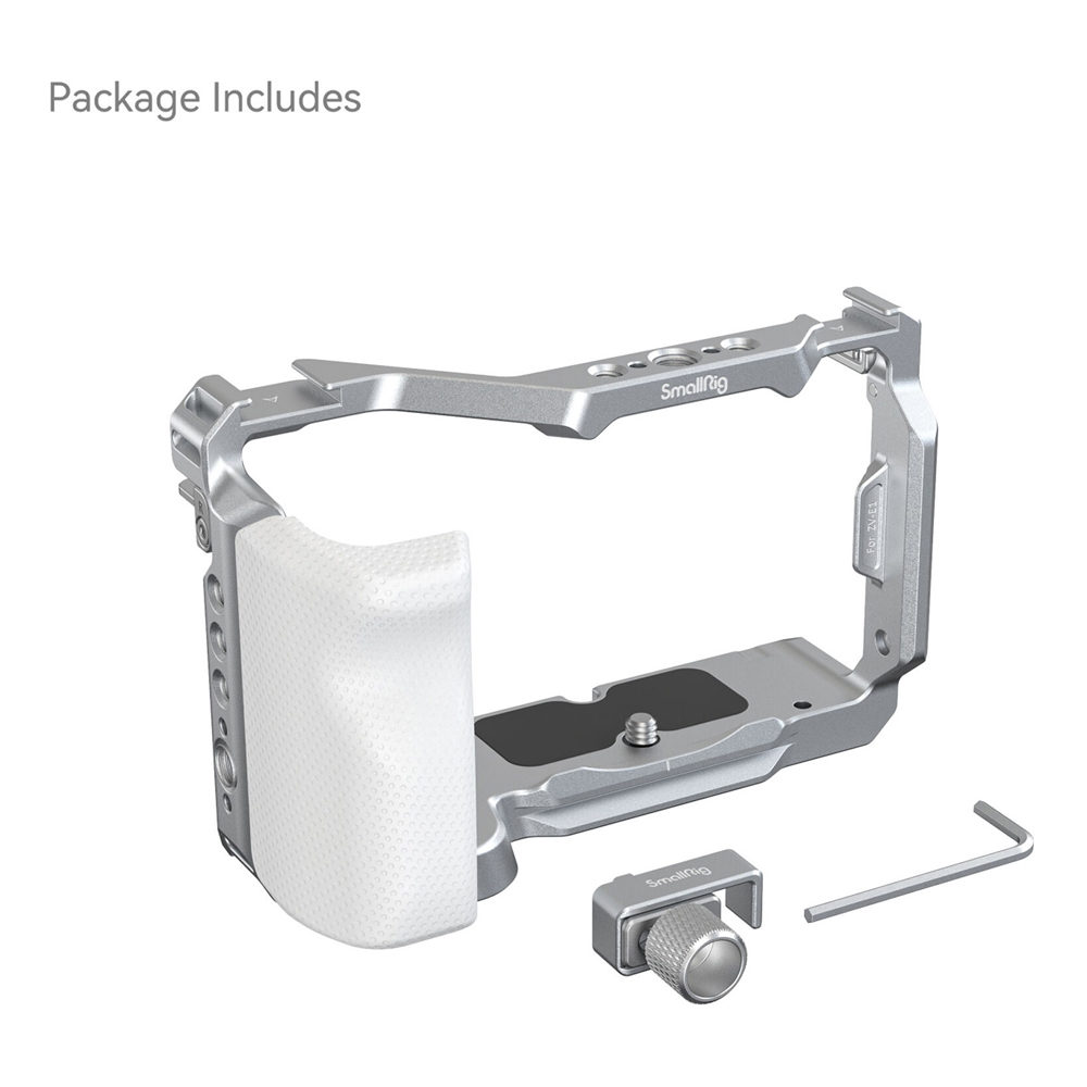 1694593857_238 SmallRig 4320 Cage Kit Sony ZV-E1:lle (rajoitettu erä) sisältää hopeanvärisen kamerahäkin, jossa on valkoinen kahva, kompaktin kiinnitystarvikkeen ja kuusiokoloavaimen, jotka kaikki näkyvät valkoisella pinnalla. "Package Includes" näkyy vasemmassa yläkulmassa.