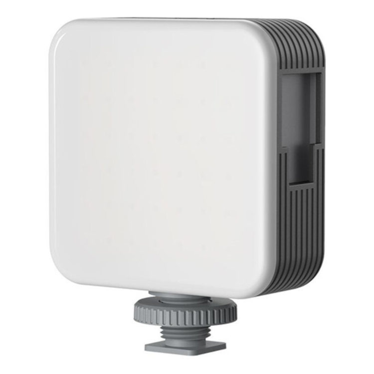 1695039246_389 SmallRig 4276 Full Color Mini LED Video Light Vibe P108 on valkoinen, neliönmuotoinen laite, jossa on pyöristetyt reunat, harmaa harjattu pohja, liitin alareunassa ja tuuletusaukot sivuilla.