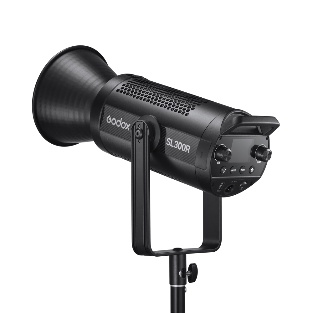 1698323068_876 Mustan värinen Godox SL300R RGB LED Video Light -LED-valo on asennettu jalustalle, ja sen ohjauspaneeli, säätönuppi ja suuri sylinterimäinen heijastin ovat esillä.