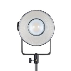1698323707_971 Pyöreällä heijastimella ja keskuslampulla varustettu Godox SL150R RGB LED -videovalaisin on asennettu säädettävään jalustaan suoraan eteenpäin valkoista taustaa vasten.