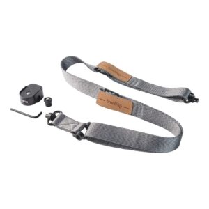 1698674742_247 SmallRig 4118B Painoa vähentävä olkahihna DJI RS 3/RS 3 Pro/RS 2/RSC 2:lle on kuvassa harmaa kangashihna ruskeilla nahka-aksenteilla, musta kiinnityslevy, ruuvi, kuusiokoloavain ja pieni rengas valkoisella pohjalla.
