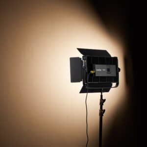 1704806425_567 Godox P200BI Studio LED-valopaneeli, joka on asennettu jalustalle, jossa on lato-ovet, heittää fokusoidun säteen beigeen seinään, tuottaen kirkkaan pisteen, jota ympäröivät lempeät varjot.