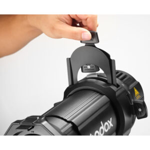 Käsi säätää Godox Spotlight Attachment MLP36K - ML30/ML60 LED-valo -studiovalaisimen kiinnikettä valkoista taustaa vasten.
