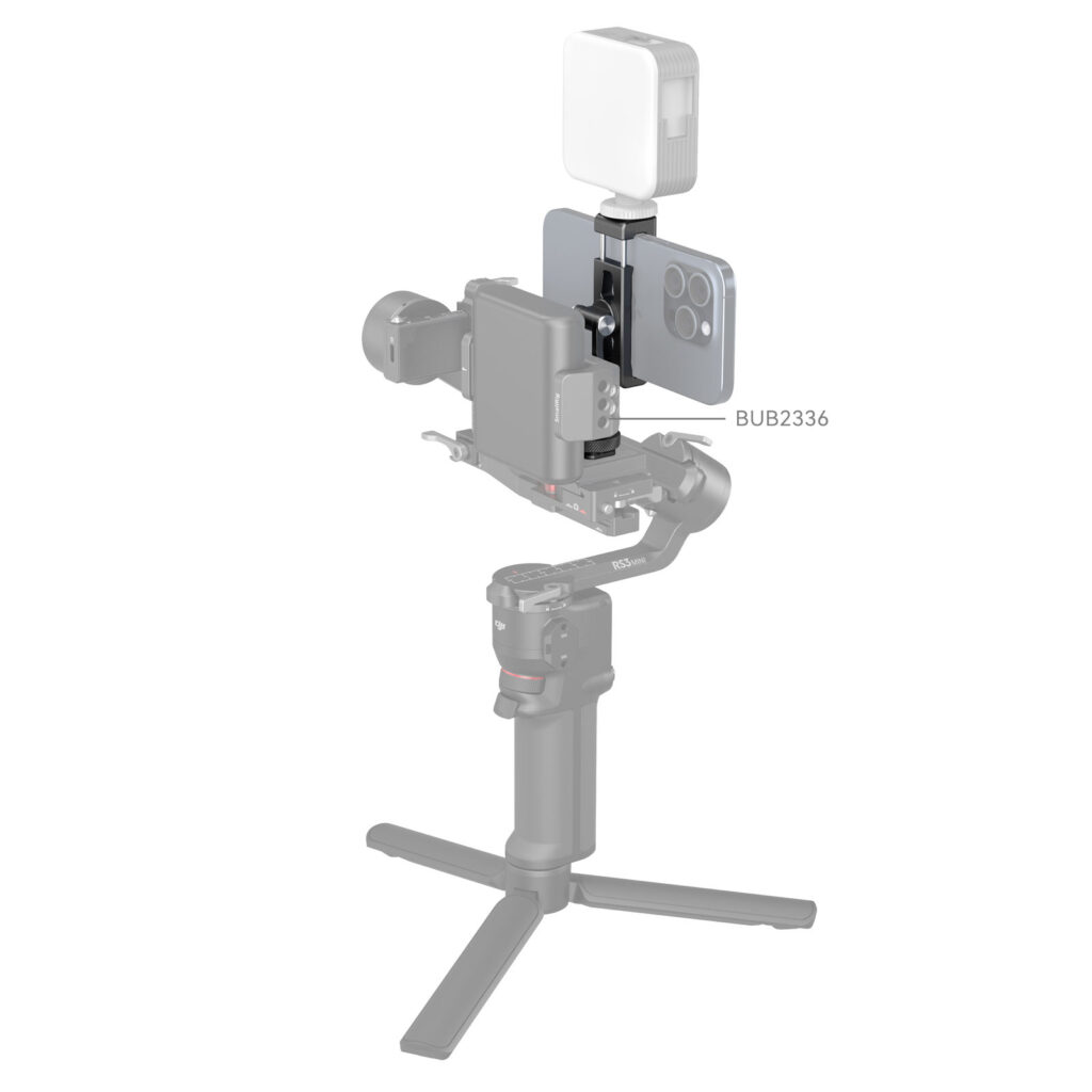 1706196183_289 SmallRig 4382 Metal Phone Holder with Cold Shoe Mount pitää älypuhelimen tukevasti käsikannettavassa gimbalissa, ja sen päälle voidaan kiinnittää LED-valo, kuten tuotekuvauksessa valkoista taustaa vasten näkyy.