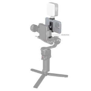 1706196183_289 SmallRig 4382 Metal Phone Holder with Cold Shoe Mount pitää älypuhelimen tukevasti käsikannettavassa gimbalissa, ja sen päälle voidaan kiinnittää LED-valo, kuten tuotekuvauksessa valkoista taustaa vasten näkyy.