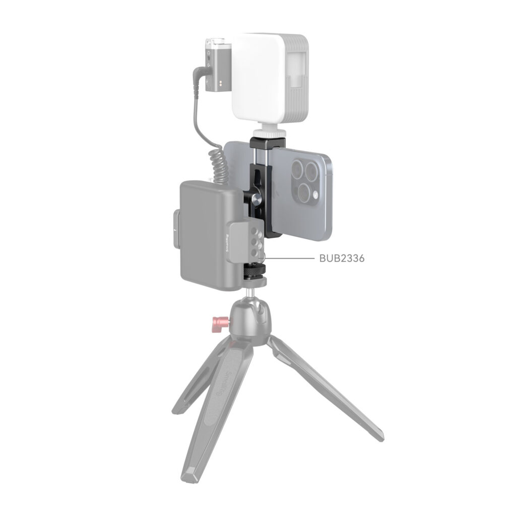 1706196185_020 SmallRig 4382 Metal Phone Holder with Cold Shoe Mount -metallipuhelinpidikkeeseen kiinnitetty älypuhelin sekä jalustalla oleva LED-valo ja ulkoinen akku esittelevät kompaktin videokuvausasetelman.