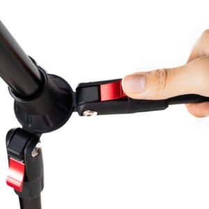 1706522479_792 Lähikuva kädestä, joka säätää SmallRig 4363 Reverse Folding Live Streaming Stand Kit Encore PT 30 -jalustan punaista vipua ja näyttää, miten jalustan jalkojen kulman säätömekanismi lukitaan tai avataan.