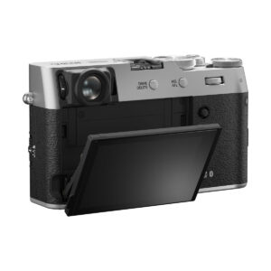 fuji_x100vi_hopea_01 Fujifilm X100VI -kompaktikamera, hopea näkyy takaa sen hopea ja musta runko. LCD-näyttö on käännetty ulos ja kallistettu alaspäin, jolloin kameran hallintalaitteet ja kuvioitu kahva paljastuvat.